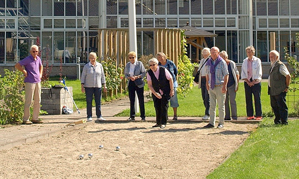 Mennesker spiller petanque foran Tolleruphøj.
